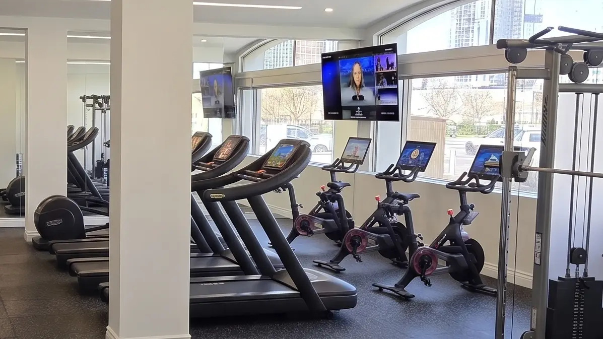 The fitness studio — treadmills, spin bikes, free weights, and big windows
